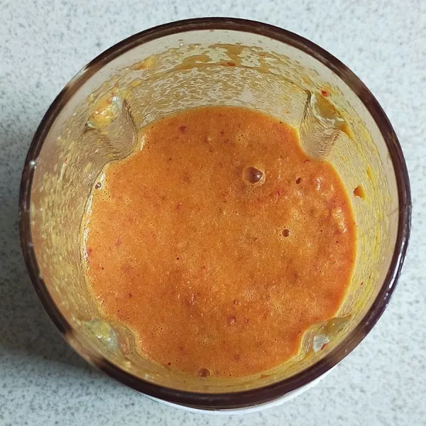 Siapkan blender, lalu haluskan bawang merah, bawang putih, kemiri, cabe merah keriting, kunyit, jahe, lada bubuk dan air hingga halus.