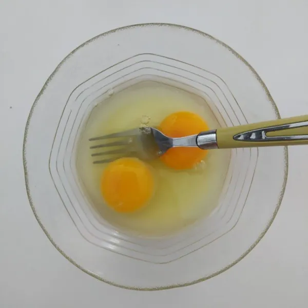 Siapkan 2 butir telur ayam dan beri garam secukupnya lalu kocok lepas