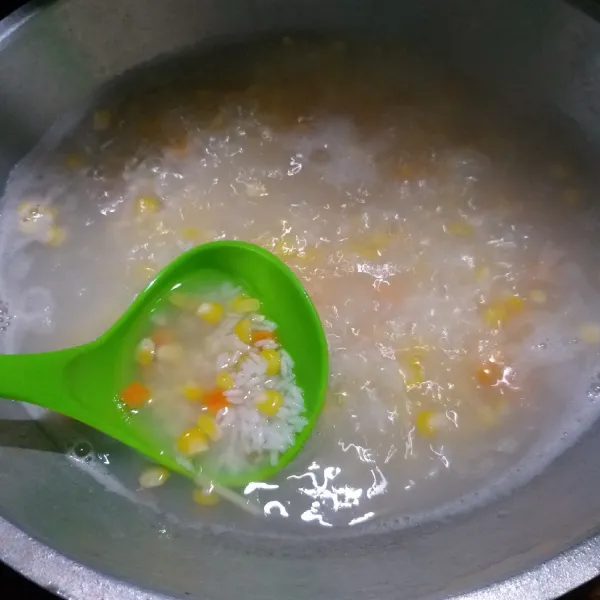 Cuci bersih beras lalu tambahkan air. Masak sampai mendidih, masukan jagung dan wortel.