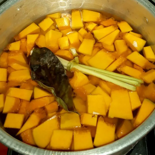 Masukkan beras, labu kuning, singkong, ubi, jagung manis, serai, dan daun salam ke dalam panci. Tuang air dan jerang diatas api. Sesekali aduk supaya tidak berkerak.