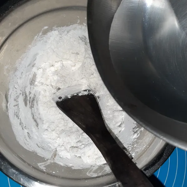 Buat sagu guntingnya. Masak air hingga mendidih. Masukkan air mendidih secukupnya ke tepung. Aduk rata dengan cepat. Kalau tidak berani, bisa gunakan spatula dulu, aduk cepat, setelah agak dingin, baru lanjutkan dengan tangan.