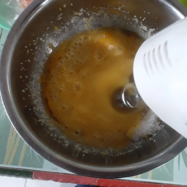 Mixer gula pasir dan telur hingga mengembang dan putih berjejak