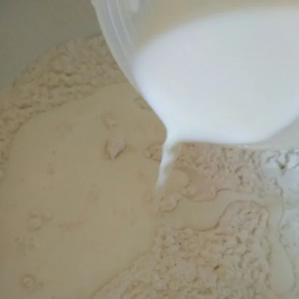 Dalam bowl masukan tepung terigu, ragi, gula pasir aduk rata tambahkan susu cair aduk hingga rata kemudian uleni hingga setengah kalis