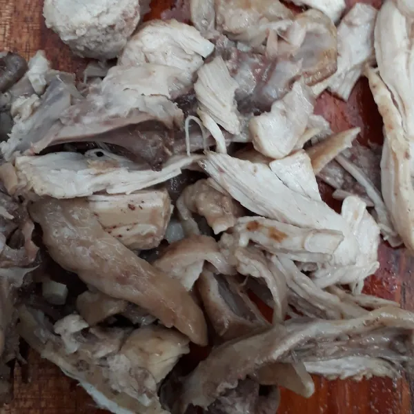 Daging ayam direbus hingga lunak lalu disuwir kasar.