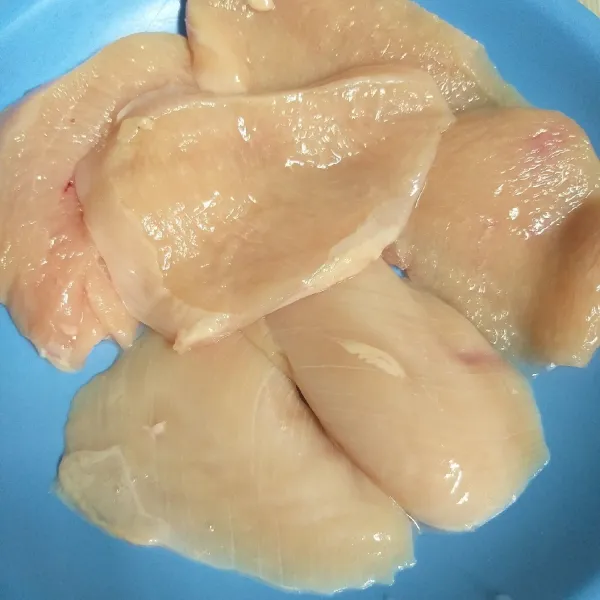 Potong tipis-tipis dada ayam secara lebar, dan bilapwrlu dipukul-pukul agar lebih tipis. Keringkan dengan tisu dapur.