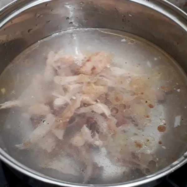 Masukan kaldu ayam cair, suwiran daging ayam, minyak wijen, saus tiram dan lada bubuk lalu didihkan.