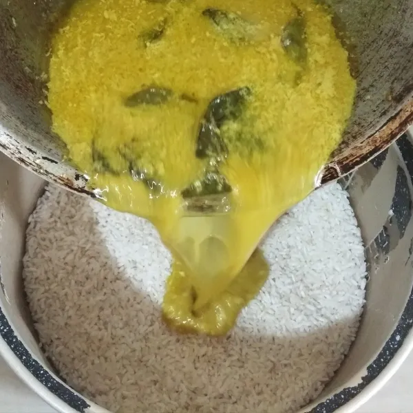 Masukkan bumbu nasi kuning ke dalam teflon magicom yang berisi beras.