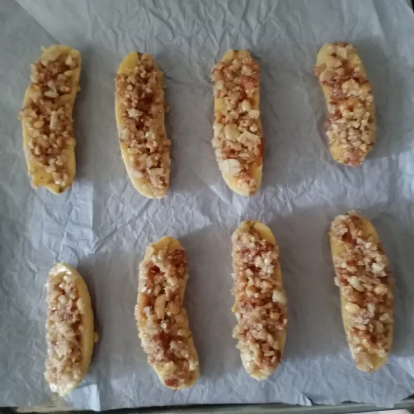 Ambil 1 pisang, lalu balur bagian atasnya dengan adonan kacang. Letakkan di atas loyang yang sudah dialasi kertas roti. Lakukan sampai selesai.