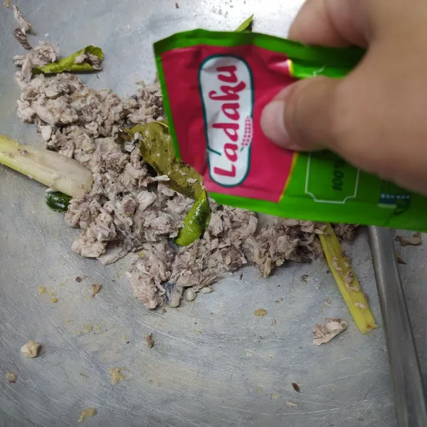 Masukkan suwiran ikan tongkol. Bumbui garam, gula, kaldu jamur, merica bubuk, dan gula pasir. Aduk sampai rata sambil koreksi rasa sesuai selera. Tambahkan 1-2 sdm air agar tidak gosong.