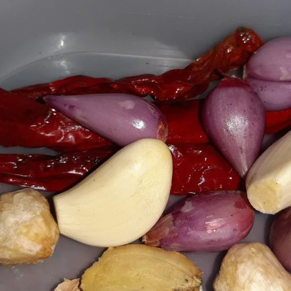 Kupas dan cuci bawang merah, putih, dan cabai lalu haluskan