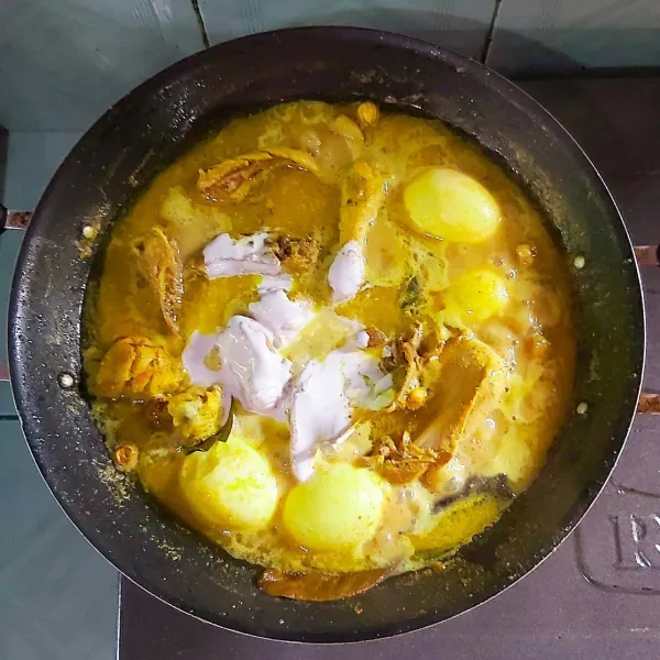 Tambahkan air, aduk rata, kemudian masukkan telur rebus. Lalu bumbui dengan garam, gula, dan penyedap rasa. Bila air sudah mendidih tambahkan santan kental. Masak hingga ayam matang dan empuk dengan kuah yang mulai menyusut dan terlihat lapisan minyak diatasnya. Matikan api dan taburkan dengan bawang goreng. Nikmat disantap dengan nasi hangat. Selamat mencoba!