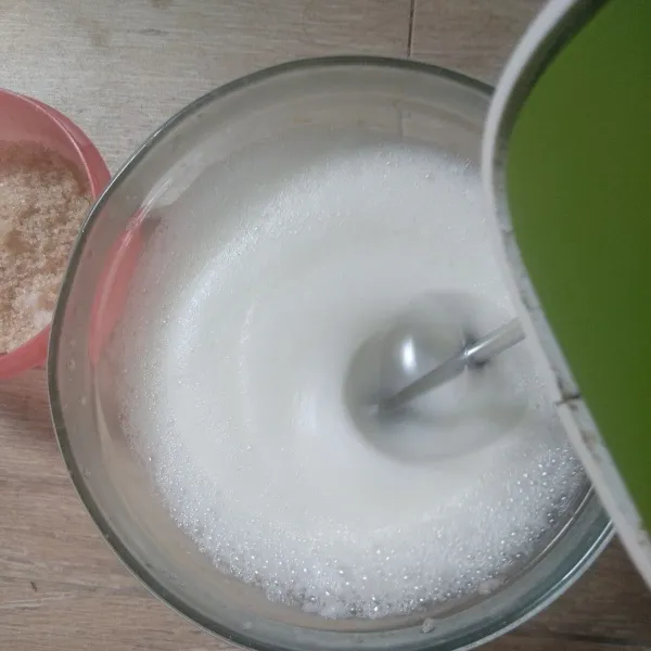 Mixer putih telur, air jeruk nipis, dan garam sampai muncul busa. Masukkan gula bertahap 3 kali sampai soft peak, lalu matikan mixer.