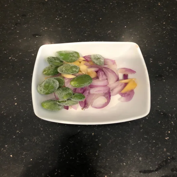 Iris 4 buah bawang merah dan 2 buah bawang putih.