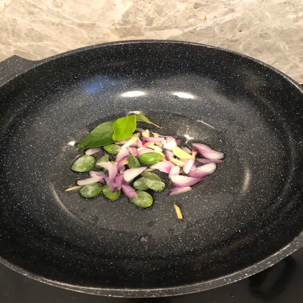 Panaskan minyak secukupnya di atas wajan lalu tumis irisan bawang, pete, dan daun salam hingga harum.