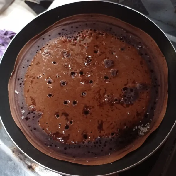 Panaskan teflon lalu tuang adonan biarkan sampai gelembung muncul, taburi gula pasir lalu tutup masak sampai matang