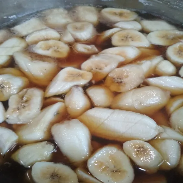 Masak gula Jawa bersama air dan daun padan hingga gula larut, masukan potongan pisang masak hingga pisang empuk