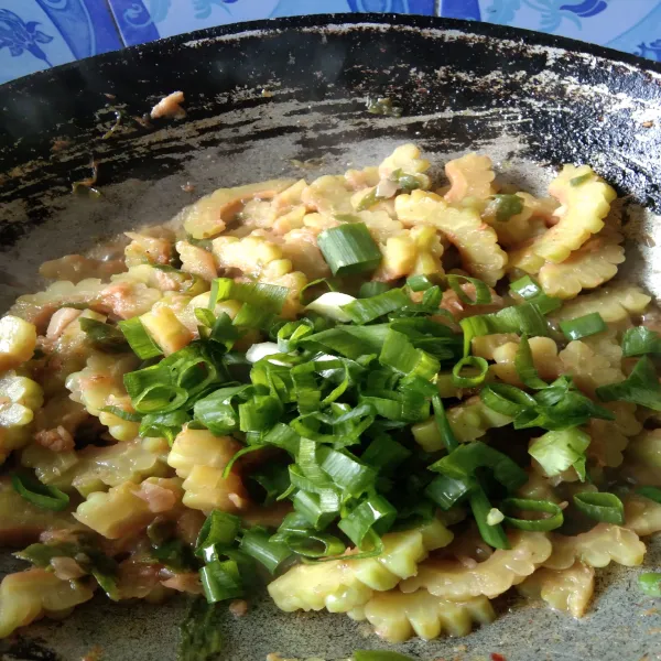 Tambahkan irisan bawang daun, aduk rata masak hingga bawang layu