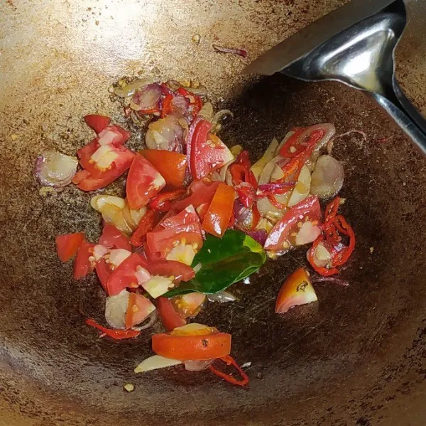 Masukan irisan tomat, tumis kembali hingga tomat layu.