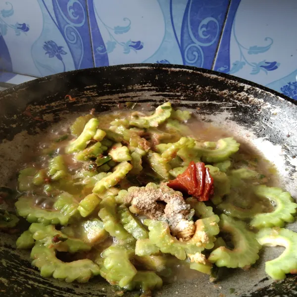 Tambahkan air, garam dan gula merah masak hingga pare empuk