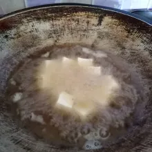 Potong dadu tahu kemudian goreng sampai setengah matang .
