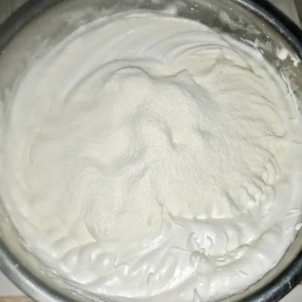 Tambahkan tepung terigu, susu bubuk dan baking powder sambil diayak. Mixer dengan kecepatan paling rendah sebentar saja cukup asal rata.