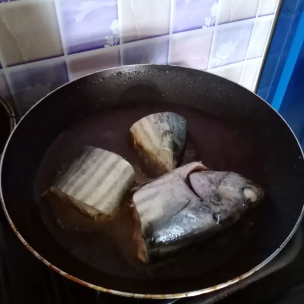 Bersihkan ikan, kemudian potong-potong. Goreng ikan sampai matang.