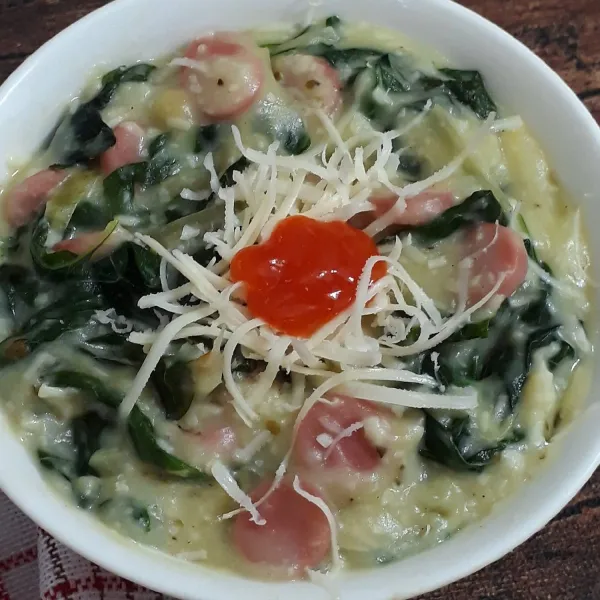 Sendokkan spinach cheese cream ke tempat saji, tambahkan keju cheddar parut dan saus cabe / saus tomat lalu sajikan.