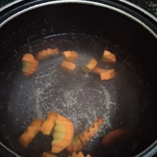 Rebus air hingga mendidih, lalu masukan wortel. Tunggu hingga wortel setengah matang.
