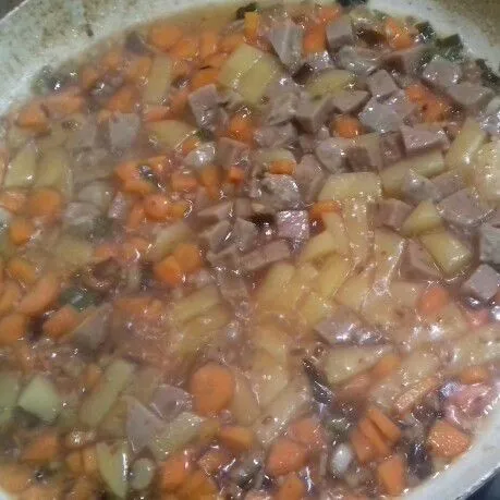Masukkan wortel, kentang dan bakso. Beri sebagian air. Masak hingga sayuran matang dan empuk.