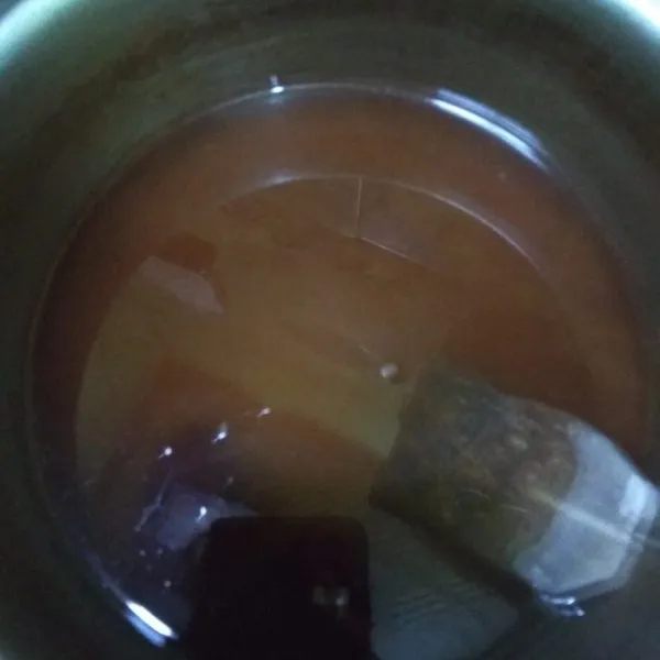 Air yang disaring masukan kembali ke panci, bersama gula merah, gula pasir dan teh celup