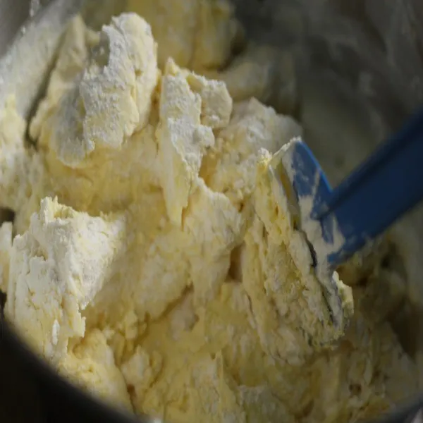 Tuang campuran tepung ke adonan dan aduk dengan bantuan whisker atau spatula.