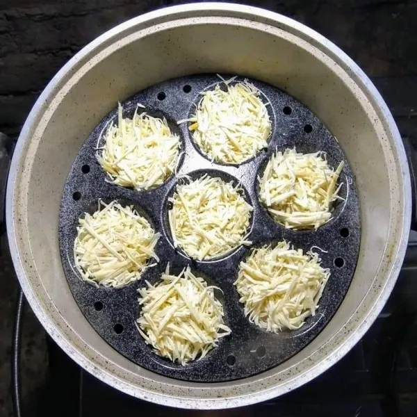 Siapkan langseng, panaskan air, olesi cetakan dengan minyak, masukan parutan singkong ke dalam cetakan sampai penuh, sambil ditekan-tekan, tutup dan kukus sampai setengah matang