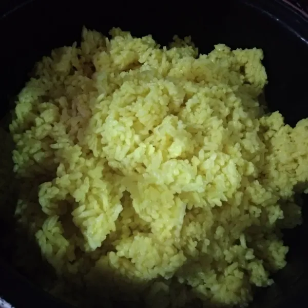 Matikan kompor dan pindahkan nasi ke dalam wadah. Nasi kuning siap disajikan dengan pelengkapnya.