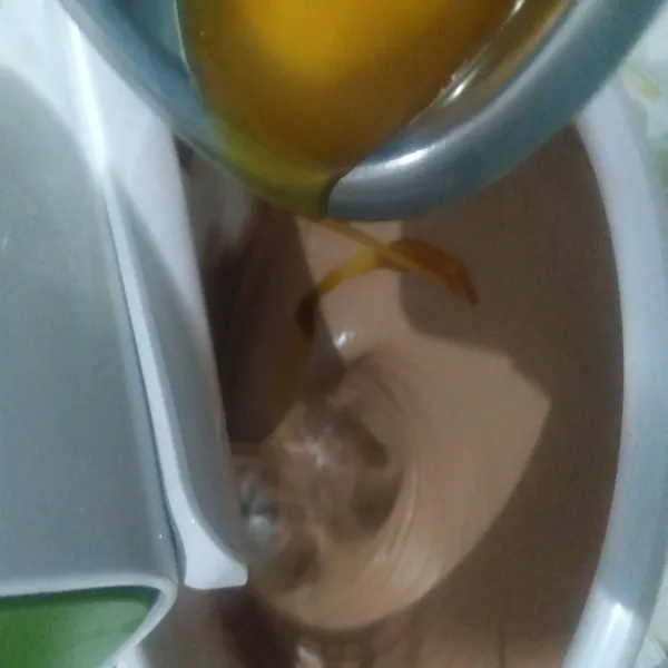 Masukan juga margarin cair ke dalam adonan dan masih pada kecepatan 1. Setelah tercampur rata. Matikan mixer. Masukan juga pasta coklat blackforest. Aduk rata dengan spatula.