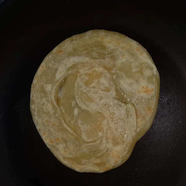 Angkat perlahan adonan yang sudah ditipiskan, kemudian pindahkan dalam teflon yang telah panas. Masak roti maryam hingga matang. Lakukan hal yang sama pada adonan lainnya.