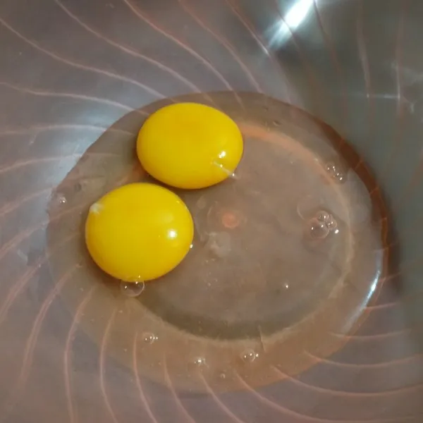 Pecahkan telur di wadah, kocok rata
