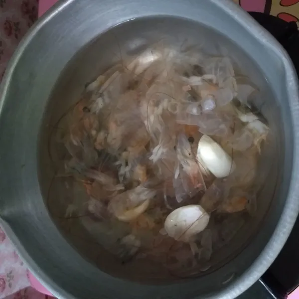 Panaskan air, kemudian rebus udang bersama bawang putih yang sudah digeprek, hingga udang berubah warna, dan kuah menyusut menjadi sekitar 500 ml.