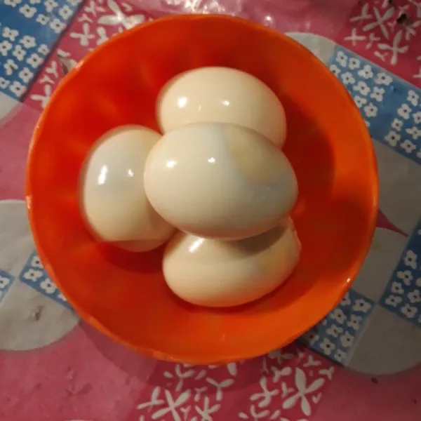 Rebus telur hingga matang lalu kupas.