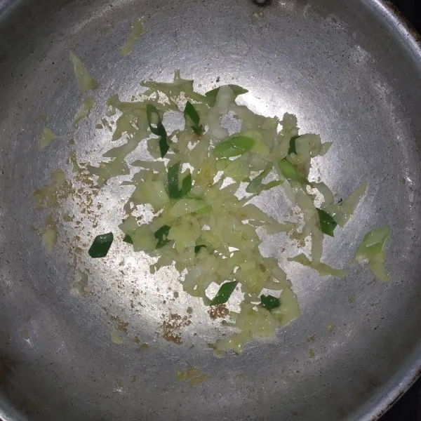 Tumis bawang putih yang sudah digeprek hingga harum, kemudian masukkan kol dan daun bawang, oseng hingga sayuran layu.