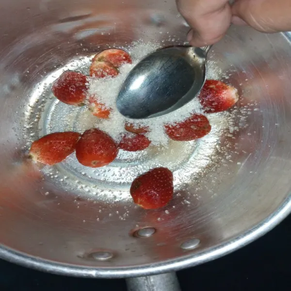 Tambahkan gula, tekan tekan strawberry menggunakan sendok hingga setengah hancur.