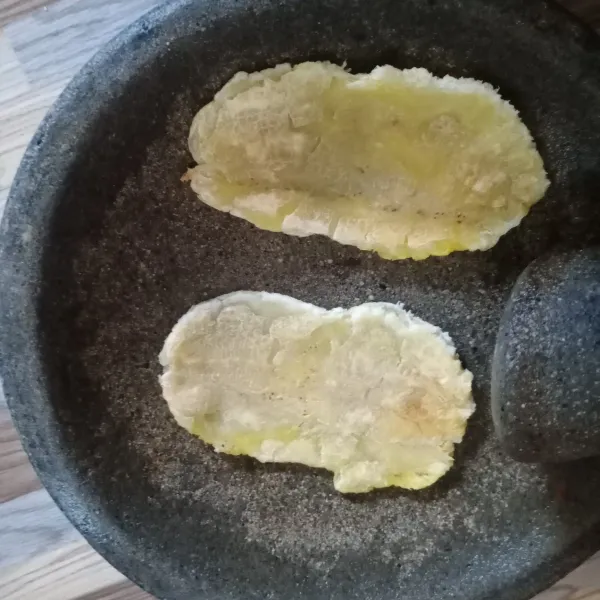 Letakkan pisang di cobek, kemudian pipihkan menggunakan ulekan.