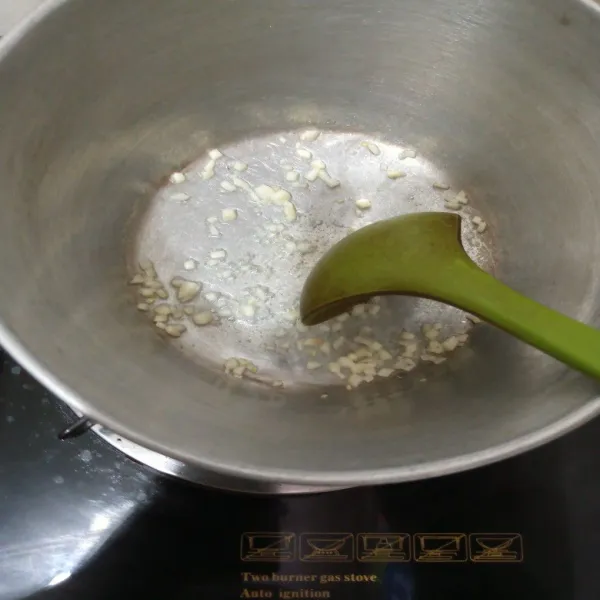 Tumis bawang putih rajang dengan minyak hingga harum.