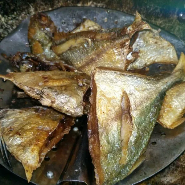 Lumuri ikan dengan garam dan air jeruk nipis, lalu goreng ikan hingga matang.