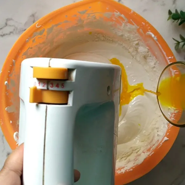 Turunkan kecepatan mixer sampai yang terendah, kemudian masukkan tepung terigu. Mixer perlahan, kemudian masukkan santan dan jus jeruk.