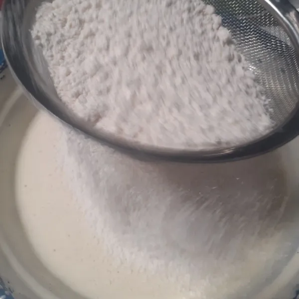 Jika sudah kental berjejak, masukkan tepung terigu dan garam sambil diayak.