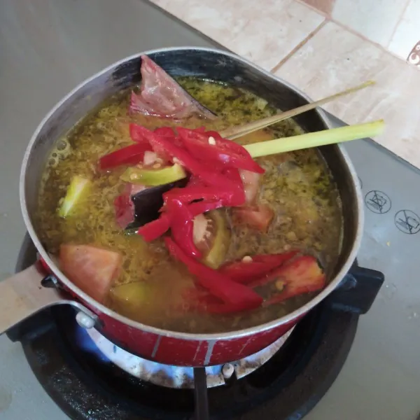 Tambah air, masak sampai mendidih kemudian masukan ikan, cabai, tomat, lengkuas dan sereh. Masak sampai ikan matang