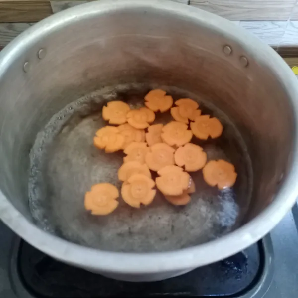 Didihkan air di panci, kemudian masukan wortel. Masak sampai wortel setengah matang.