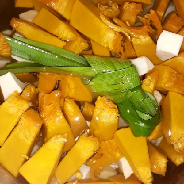 Masukkan air ke dalam panci. Masukkan pula waluh, ubi dan daun pandan. Rebus sampai 1/2 empuk.