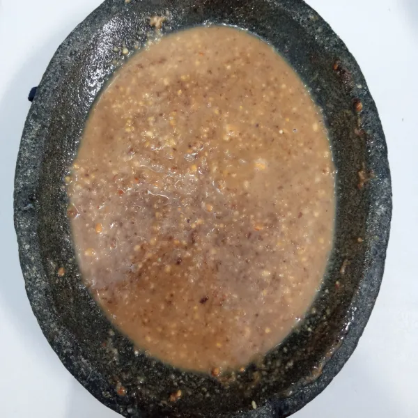 Ulek bumbu sampai halus. Tambahkan air hangat. Aduk rata. Kemudian tuang di atas telur.