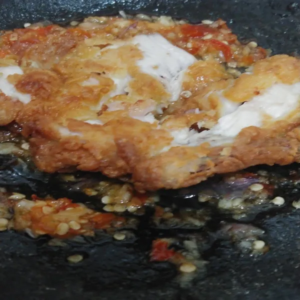 Ambil 1 potong ayam lalu geprek dengan ulekan.